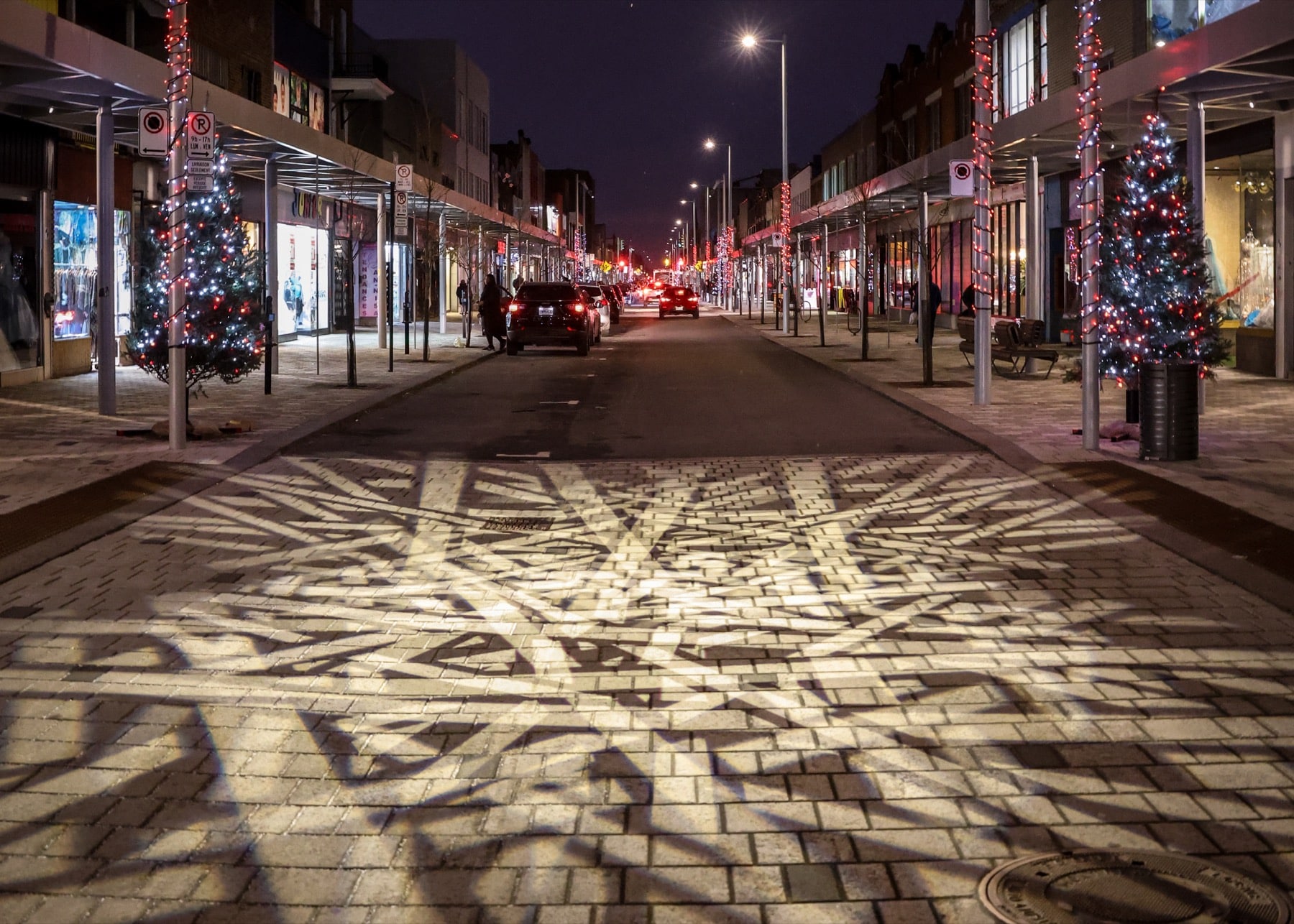 Omium - Groupe Ombrages - Conception lumière - illumination - design - ingénierie - éclairage urbain - projection lumineuse sur le trottoir et la chaussée de l'artère commerciale de la Plaza Saint-Hubert à Montréal